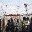 Visitors walk near a wire fence 이미지